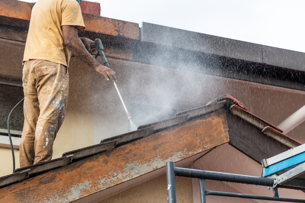 Worker,Using,High,Pressure,Water,Jet,Spray,Gun,To,Wash